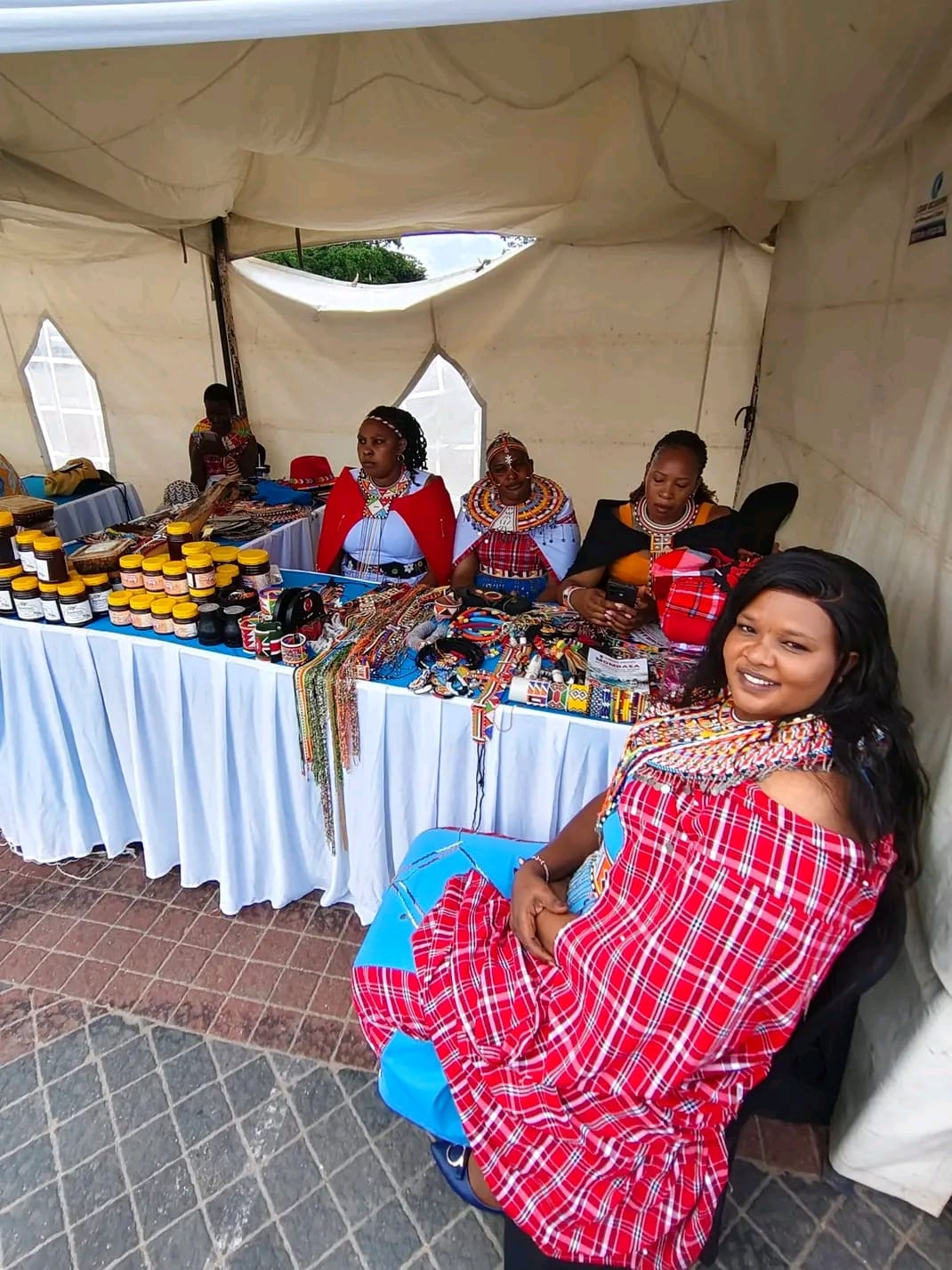Namelok women presenting beadwork and honey products